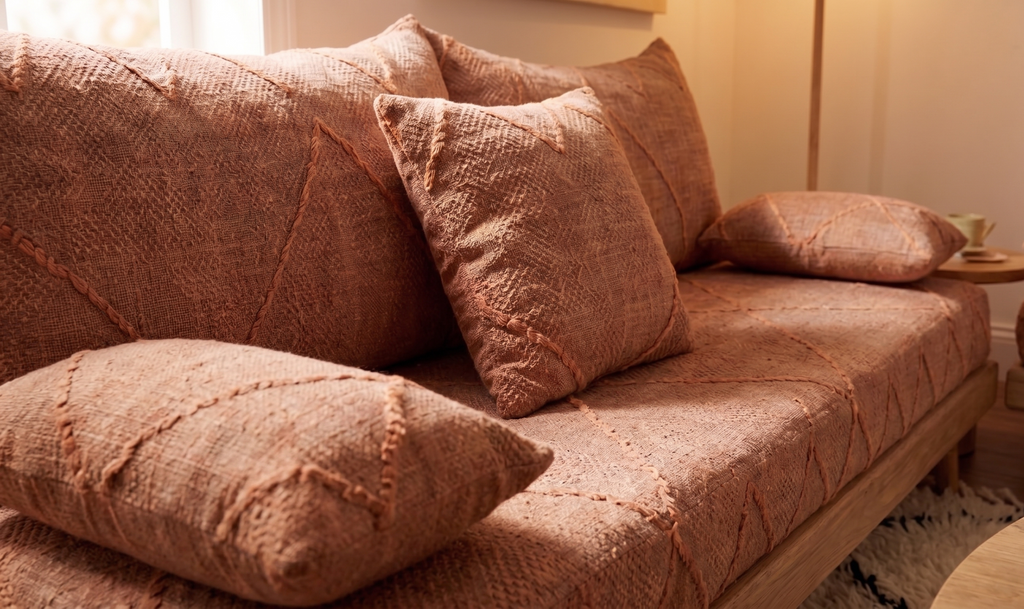 Handcrafted Moroccan low-profile sofa set with terracotta cotton cushions and natural wood frames in a warm, modern living room.