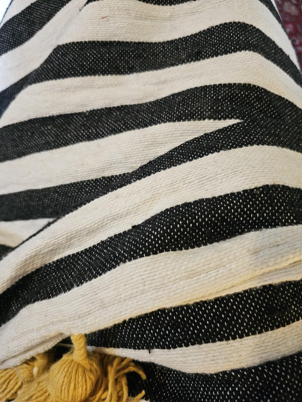 Close-up of a black and white striped fabric with tassels.